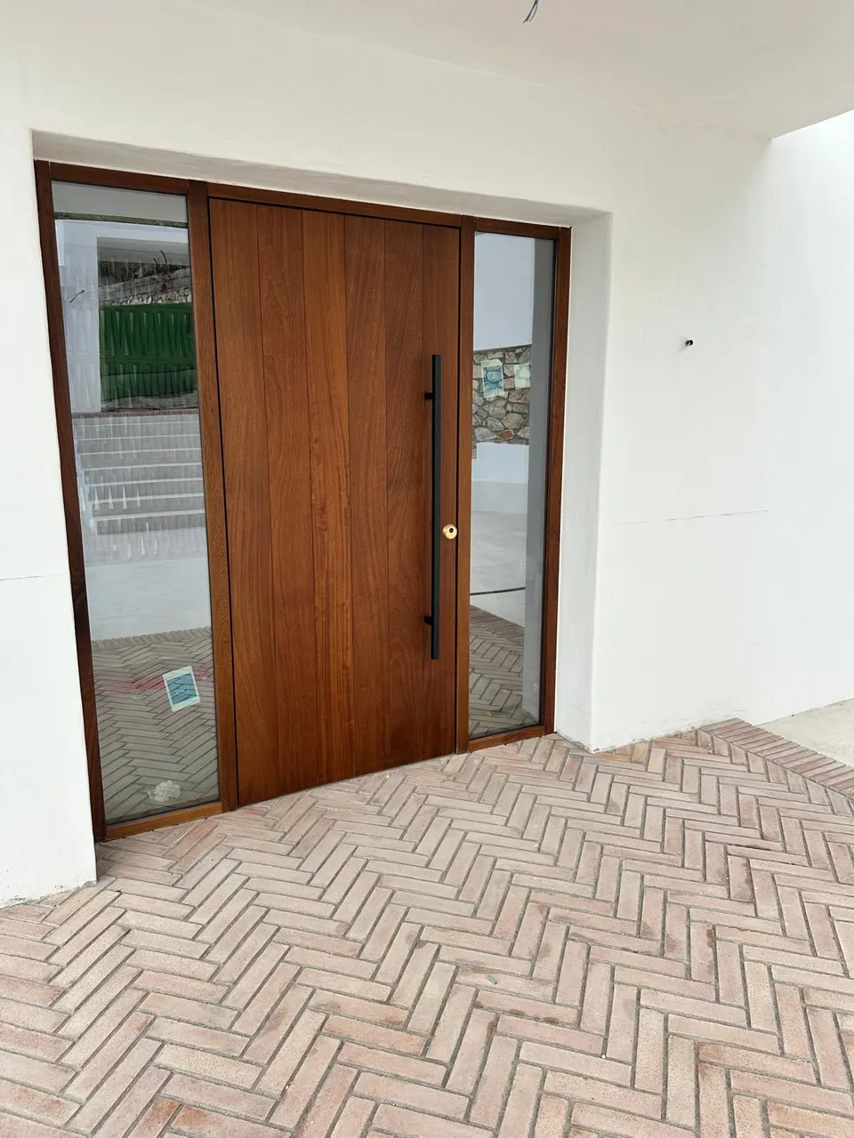 Puerta de entrada de madera maciza con fijos de vidrio